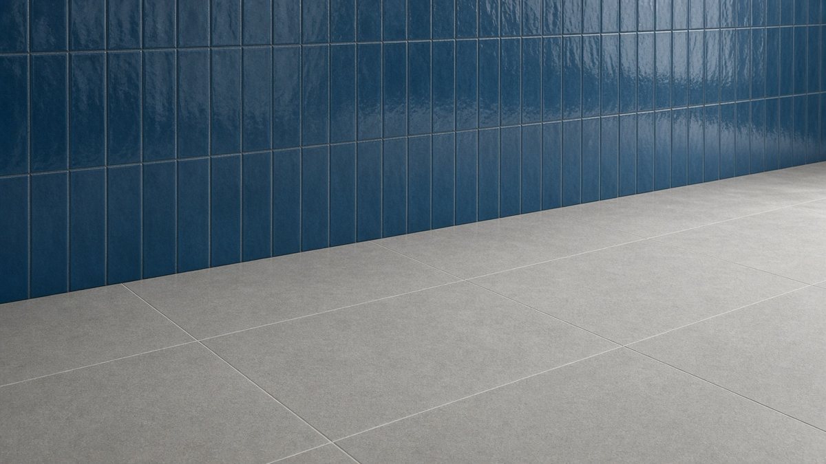 Grey porcelain floor tiles meeting an ocean-blue glazed tile feature wall.